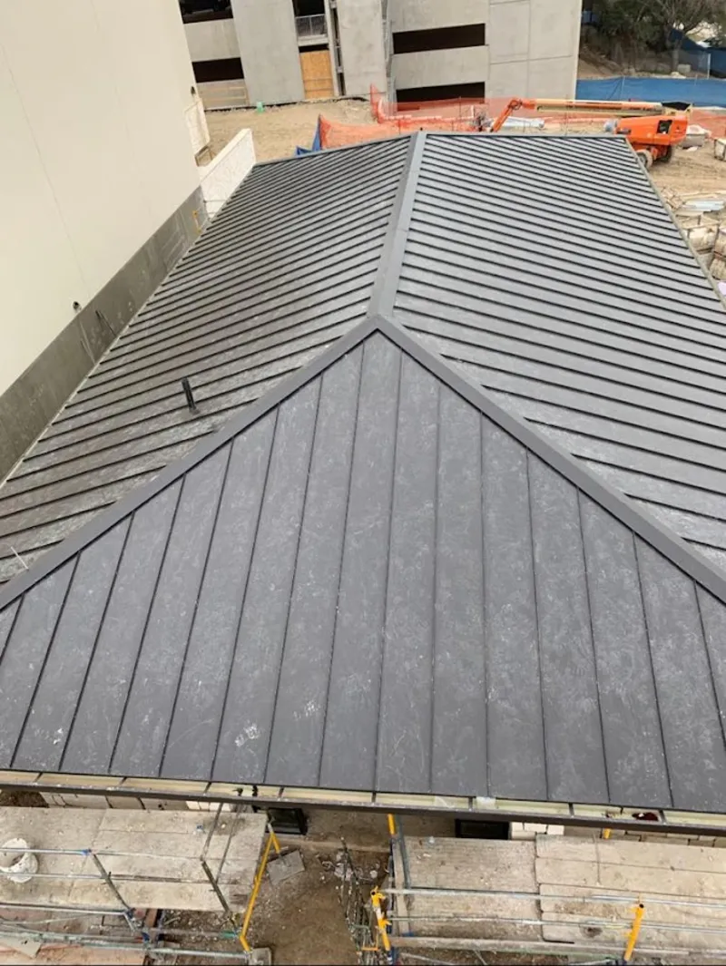 Commercial metal roof construction with crane equipment in Hamilton